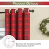 Close-up of red plaid curtains with grommets, and a detail of a grommet with measurements, next to a Christmas wreath. Produktbild-Vorschau