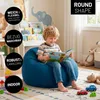 A young boy is reading a book while sitting on a blue beanbag chair in a child's room. The room has a bookshelf with books, stuffed animals, and toy cars. Voir les images du produit