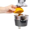 A hand is holding a halved orange over a manual citrus juicer. Voir les images du produit