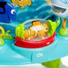 A close-up of a baby walker with a Finding Nemo theme. The focus is on a clownfish toy inside a clear dome, surrounded by green seaweed-like structures and a red base. Other cartoon fish characters are visible in the background. Produktbild-Vorschau