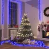 A festive Christmas scene with a decorated tree, fireplace, stockings, and gifts, illuminated by blue LED lights. Voir les images du produit