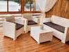 A white wicker outdoor furniture set, including two armchairs, a sofa, and a coffee table, is arranged on a wooden deck overlooking a body of water. Anteprima dell’immagine prodotto