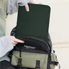 A person is putting a green laptop sleeve into a backpack. Náhled obrázku produktu
