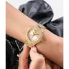 A close-up shot of a gold Guess watch with crystal embellishments on a person's wrist. Podgląd zdjęcia produktu