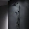 A black shower system mounted on a dark gray wall. Produktbild-Vorschau