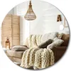 A cozy living room scene with a sofa, blankets, and decorative items. Produktbild-Vorschau
