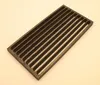 A dark gray, rectangular grate with multiple parallel slots is placed on a light gray surface. Produktbild-Vorschau