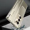 A close-up shot of a gold-colored foldable phone case with a built-in stand, resting on a cracked marble surface against a dark gray background. Náhled obrázku produktu