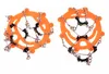 Two orange shoe crampons with metal chains and black fasteners, isolated on a white background. Náhled obrázku produktu
