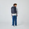 A young person wearing a backpack, viewed from the back. Voir les images du produit