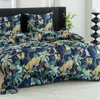 A close-up view of a bed with a duvet cover and pillows featuring a jungle-themed print with leopards and tropical plants. Náhled obrázku produktu