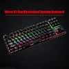 A black mechanical keyboard with rainbow backlighting is displayed on a dark, textured background. Produktbild-Vorschau