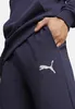 A close-up shot of a person's hand in the pocket of navy blue sweatpants with a PUMA logo. Náhľad obrázku produktu