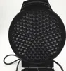 A top-down view of an open black waffle iron with heart-shaped molds. Náhled obrázku produktu