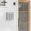 A gray mailbox with an owl design is mounted on a white, horizontally paneled exterior wall next to a wooden door. Produktbild-Vorschau
