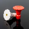 Two nozzles, one red and one white, are placed on a reflective black surface. Náhled obrázku produktu