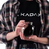 A person is holding a glass jar filled with a dark liquid. Anteprima dell’immagine prodotto