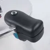 Close-up of a black handle on a silver pressure cooker. Podgląd zdjęcia produktu