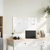 A whiteboard is mounted on a wall above a desk with a laptop and headphones. Náhled obrázku produktu