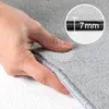 A hand is shown pressing down on a soft, gray carpet, with a close-up inset showing a measurement of 7mm. Podgląd zdjęcia produktu