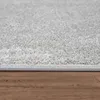 Close-up of a light gray rug with a textured surface, resting on a wooden floor. Produktbild-Vorschau