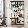 A modern home office with a black geometric bookshelf filled with books, plants, and decorative items. Voir les images du produit