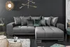 A modern living room with a large sectional sofa, decorative pillows, and a stylish chandelier. Produktbild-Vorschau