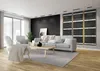A modern living room with a sofa, chairs, and a coffee table, featuring wall-mounted heating panels. Produktbild-Vorschau