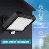 A solar motion sensor light mounted on a dark wall, with icons and text describing its features against a sky background. Produktbild-Vorschau