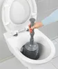 A hand is using a plunger to clear a toilet. Produktbild-Vorschau