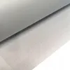 A close-up, angled view of a roll of transparent, self-adhesive anti-slip film with a grid pattern, partially unrolled onto a surface with a grid pattern. Produktbild-Vorschau