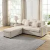 A beige sectional sofa with an ottoman is placed in a well-lit living room with large windows. Anteprima dell’immagine prodotto