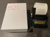 A white box with red lettering and a black label printer with a receipt are placed on a gray surface. Podgląd zdjęcia produktu