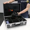 A person is holding a camera and placing it into a black tool case with dividers. Produktbild-Vorschau