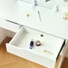 A close-up view of an open drawer on a white vanity table, with makeup products inside. Produktbild-Vorschau