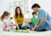A family playing a board game on the floor in a living room. Podgląd zdjęcia produktu