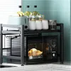 A kitchen counter with a microwave oven and a shelf organizer holding various kitchen items. Produktbild-Vorschau