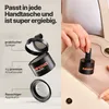 A person is placing a small black cosmetic product into a light-colored handbag. Produktbild-Vorschau