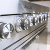 A close-up shot of the control knobs on a stainless steel grill. Podgląd zdjęcia produktu