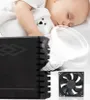 A sleeping baby next to a black electronic device with airflow depicted as a vortex. Podgląd zdjęcia produktu
