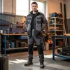 A man wearing workwear stands in a workshop. Anteprima dell’immagine prodotto