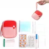 A hand holding a small red and pink pouch, with various medical supplies laid out next to it. Náhľad obrázku produktu