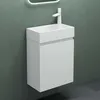 A white bathroom vanity with a sink and faucet against a textured green wall. Produktbild-Vorschau