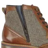 Close-up view of a brown leather and tweed boot. Voir les images du produit