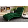 A green chaise lounge is placed in a modern living room with a fireplace and plants. Náhled obrázku produktu