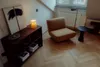 A cozy corner with a chair, side table, and shelf. Produktbild-Vorschau