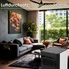 A modern living room with a sectional sofa, coffee table, and a large window overlooking lush greenery. A portable air cooler is placed in the foreground. Voir les images du produit