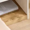 A close-up view of two books on a wooden shelf, with a white surface above. Produktbild-Vorschau