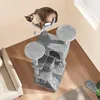 A cat is resting on a multi-level cat tree in a living room. Produktbild-Vorschau
