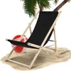 A black beach chair sits on sand next to a red and white beach ball, with a palm tree in the background. Produktbild-Vorschau